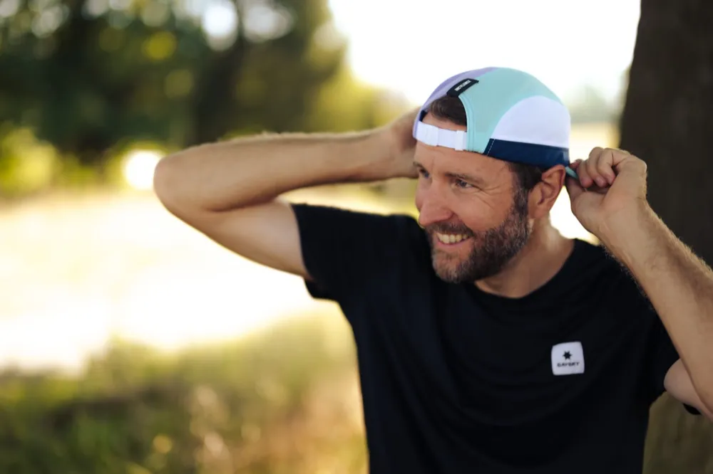 Nick lacht und rückt seine Laufkappe zurecht