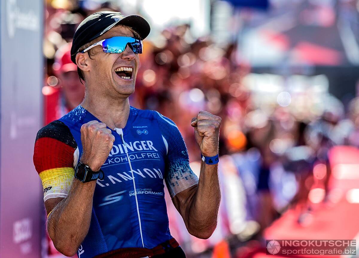 Nils Frommhold jubelt mit geballten Fäusten im Ziel des IRONMAN Südafrika 2017