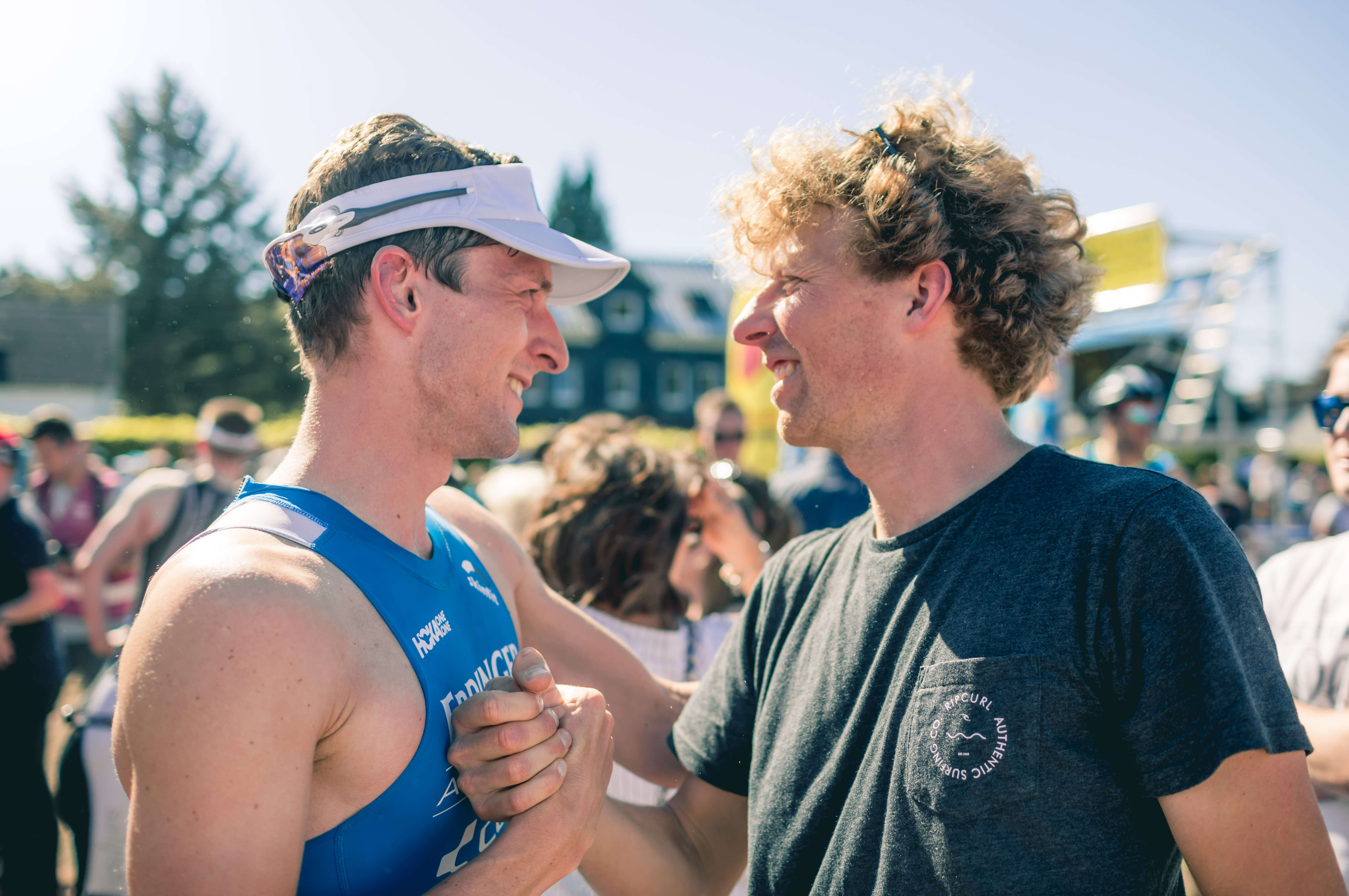 Florian Angert und sein Trainer Philipp Seipp geben sich beim Triathlon in Buschhütten lächelnd die Hand