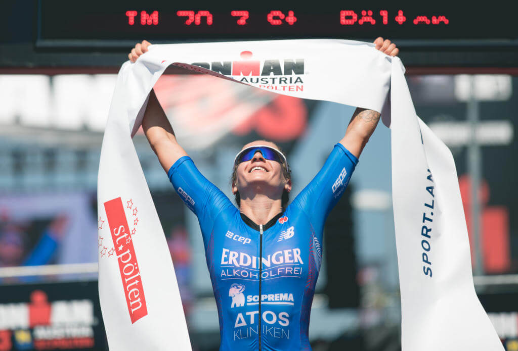 Siegerin hält beim Ironman 70.3 St. Pölten 2018 jubelnd das Zielband über den Kopf