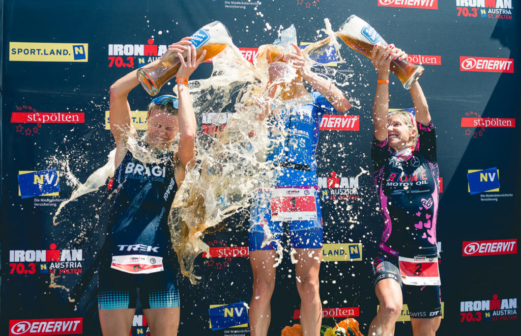 Drei Triathletinnen übergießen sich bei der Siegerehrung des Ironman 70.3 St. Pölten 2018 mit Weißbier
