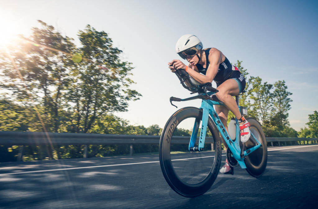 Triathletin in Aeroposition auf einem türkisfarbenen Trek-Zeitfahrrad beim Ironman 70.3 St. Pölten 2018