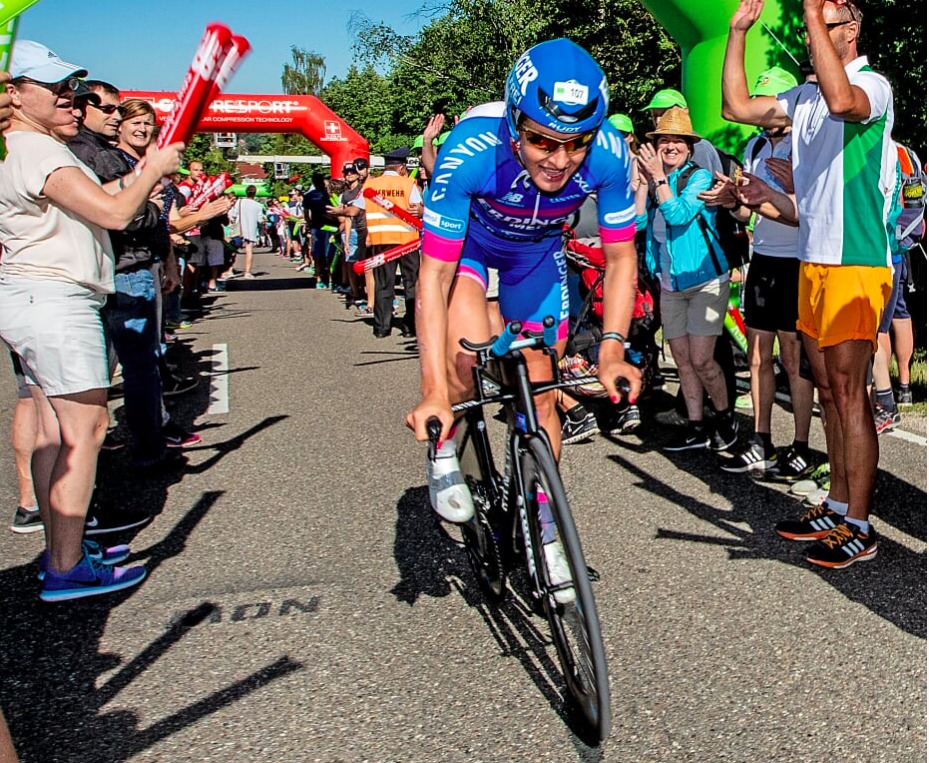 Daniela Sämmler auf dem Zeitfahrrad zwischen applaudierenden Zuschauern auf der Radstrecke der Challenge Roth