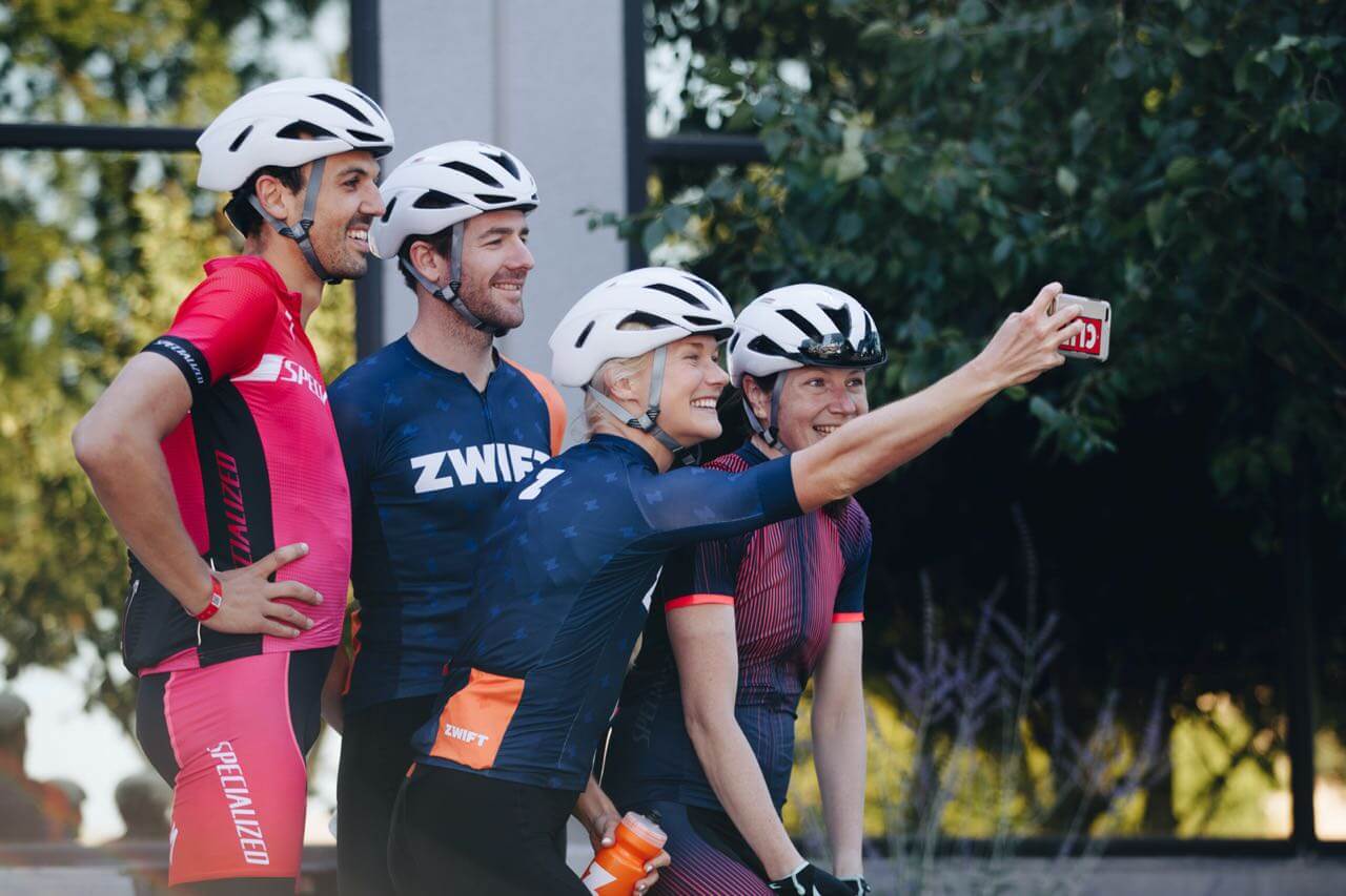 Golo Röhrken mit dem Triathlon-Team in Specialized- und Zwift-Trikots beim gemeinsamen Selfie mit Radhelmen