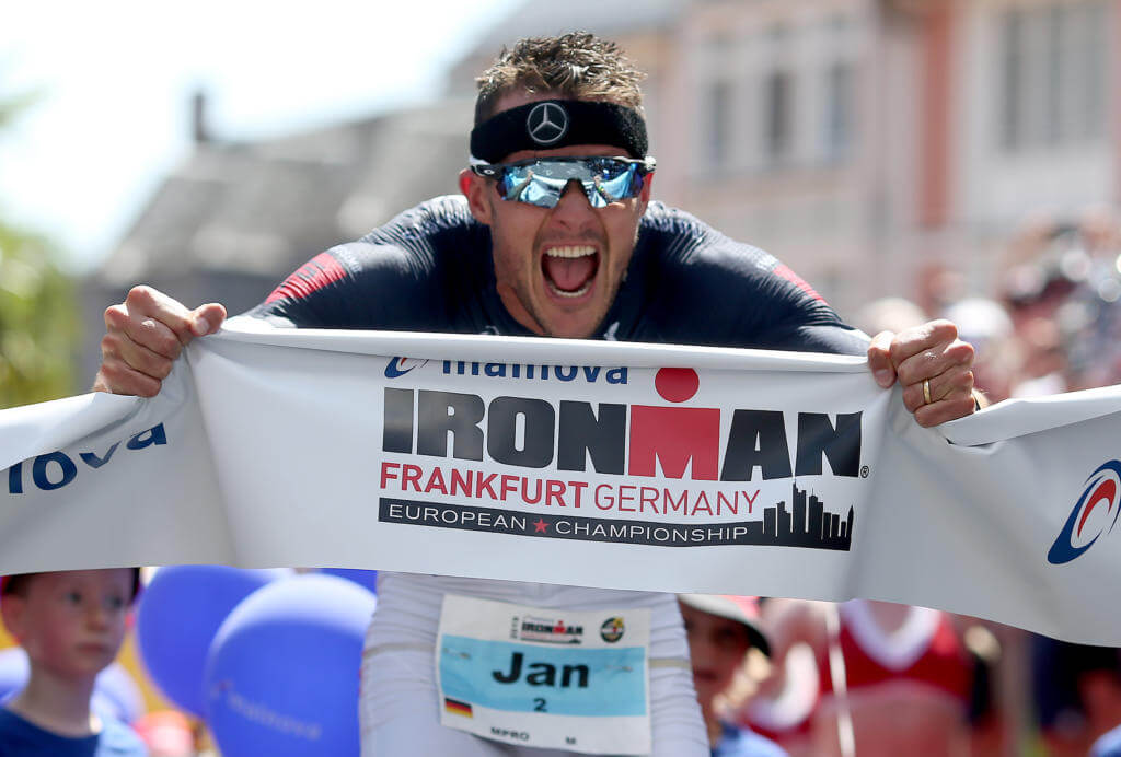 Jan Frodeno jubelt mit dem Zielbanner nach seinem Sieg bei der Ironman European Championship 2019 in Frankfurt