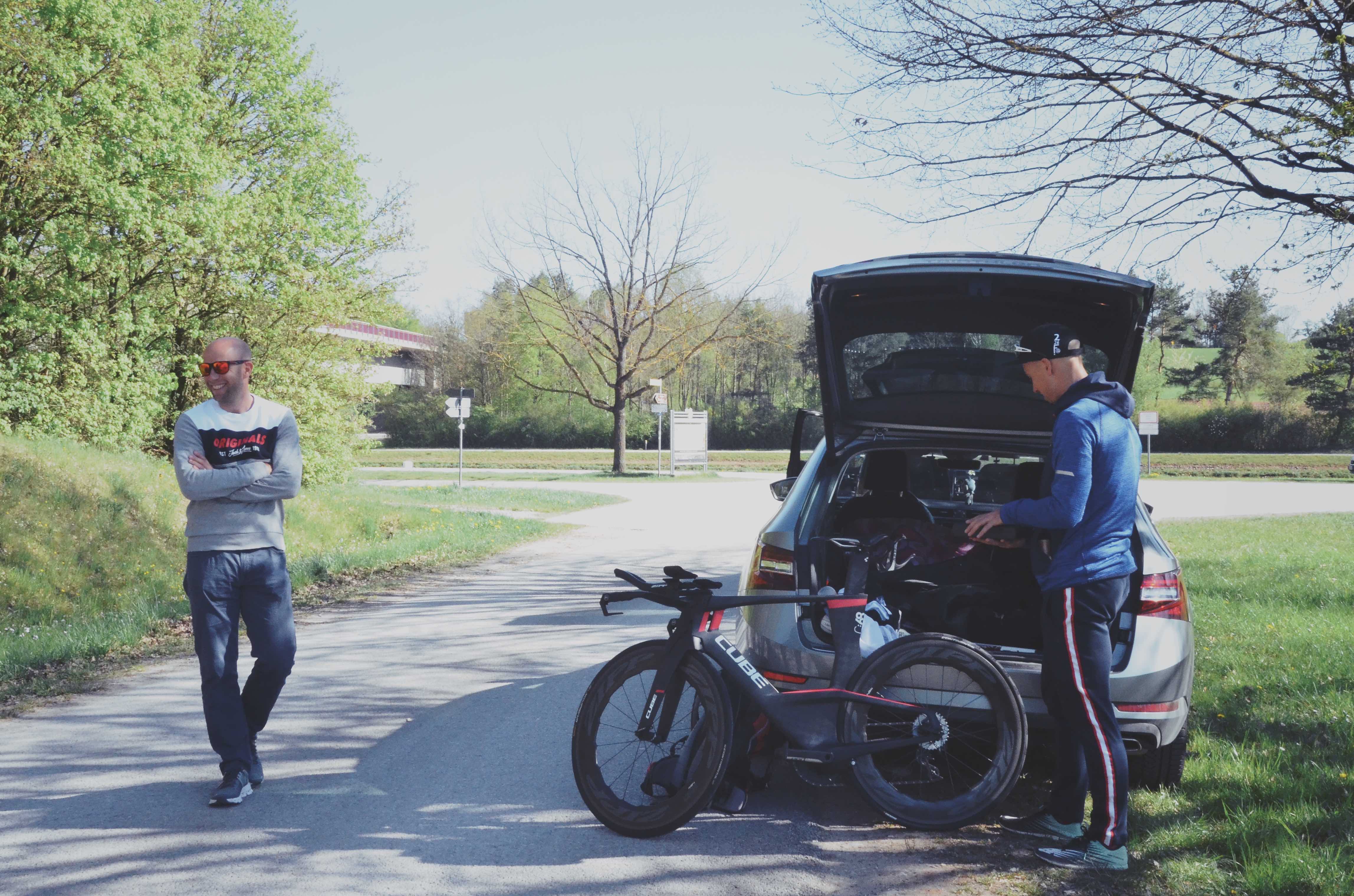 Andi Böcherer und Lubos am Auto mit offener Heckklappe, davor das Cube-Zeitfahrrad, beim Streckencheck in Roth
