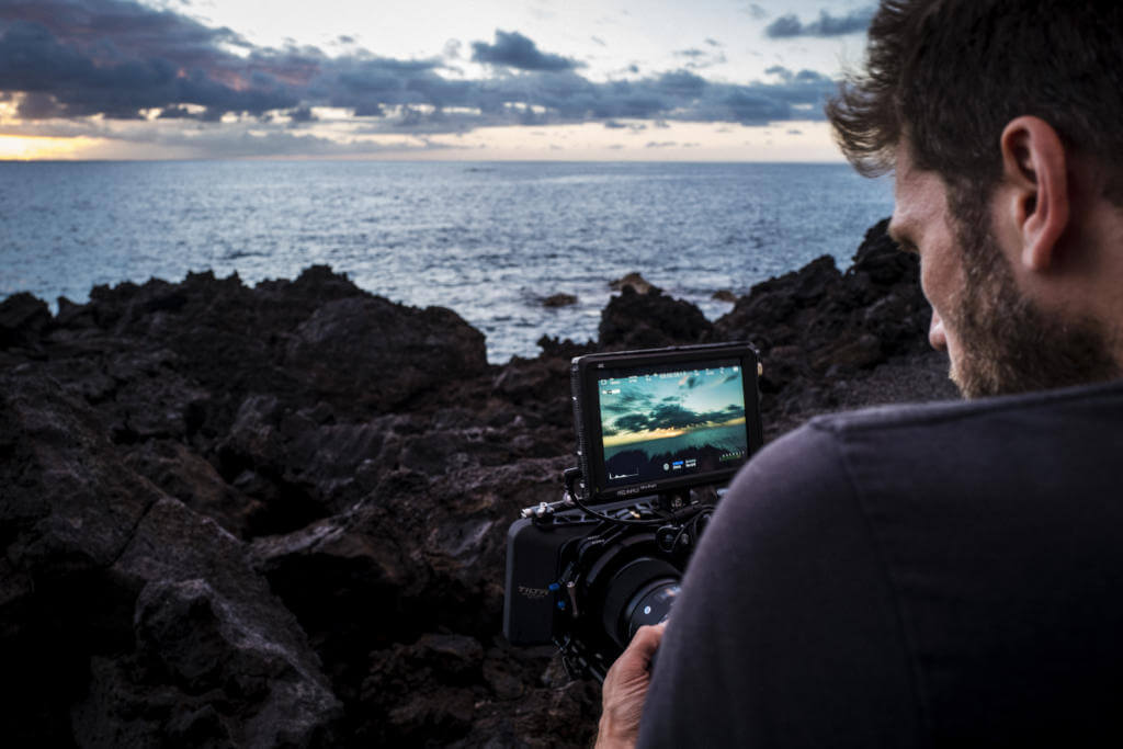 Kameramann filmt die Abendstimmung über Lavafelsen und Pazifik an der Küste von Big Island