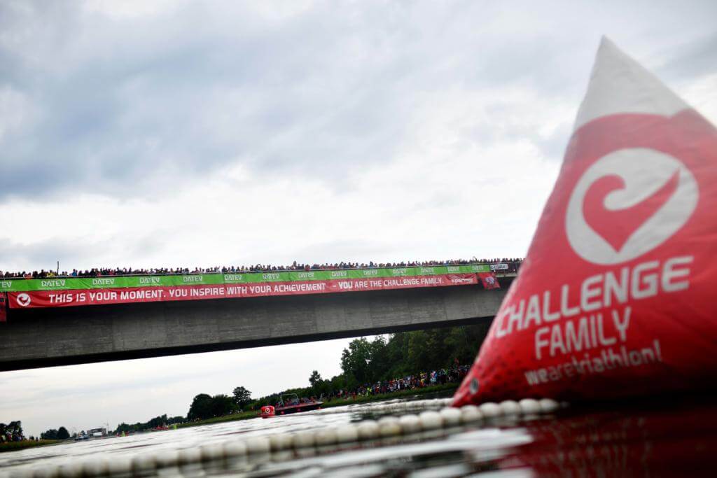 Rote Challenge-Family-Boje im Main-Donau-Kanal, dahinter die Brücke voller Zuschauer bei der Challenge Roth 2019