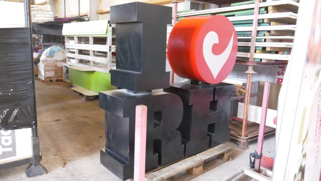 I-love-Roth-Symbol der Challenge Roth im Winterlager zwischen Regalen und Material