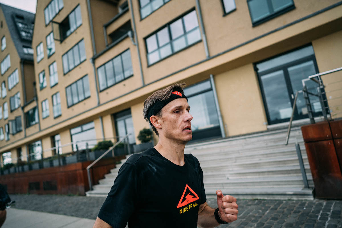 Läufer mit Stirnband und Nike-Trail-Shirt läuft beim Ultralauf von Koblenz nach Köln an einer Häuserzeile vorbei