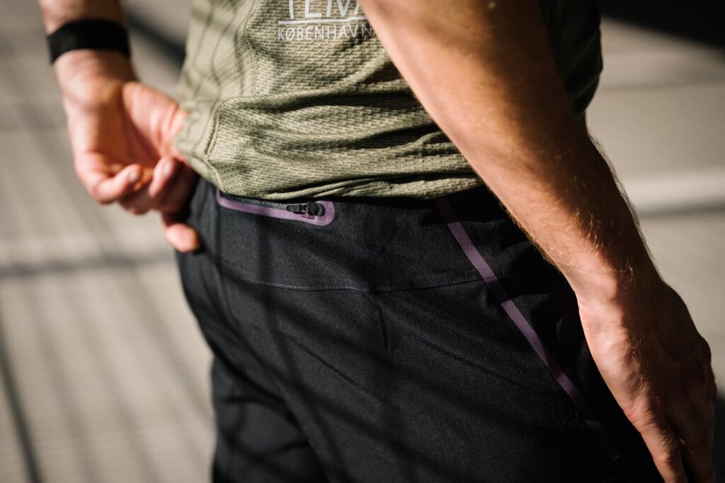 Nahaufnahme der schwarzen 2-in-1 StableRun Short von Fe226 mit Reißverschlusstasche am Bund