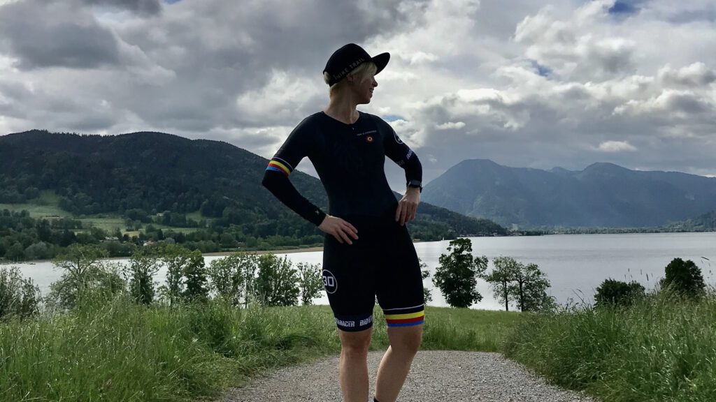 Eine Sportlerin vor einem von Bergen umgebenen See