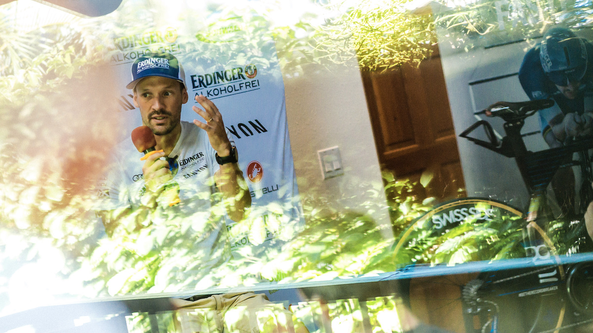 Triathlet Patrick Lange bei einem Interview durch ein Fenster fotografiert