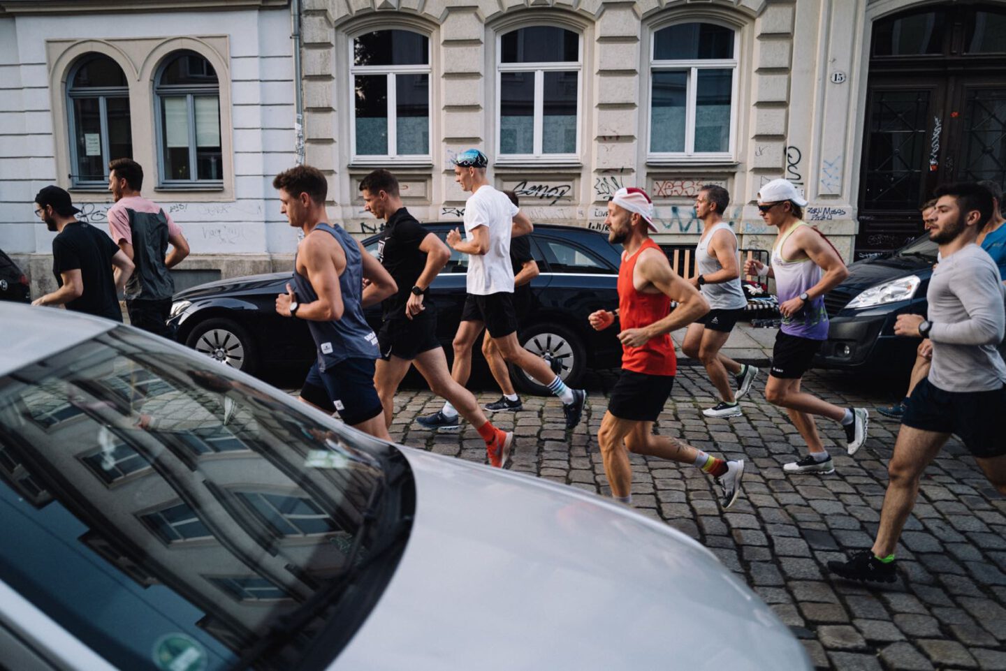 Mehrere Menschen joggen über eine Straße in einer Großstadt