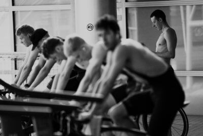 Schwarz-Weiß-Foto: Triathleten stützen sich bei den Arena Games in München auf die Lenker ihrer Räder